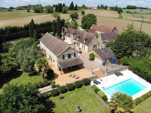 La Chapelle-AubareilLe domaine Aubazen的享有带游泳池的房屋的空中景致
