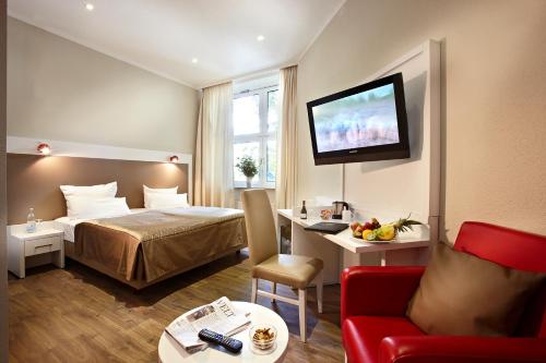 汉堡多米希尔汉堡金色郁金香酒店的酒店客房设有一张床和墙上的电视