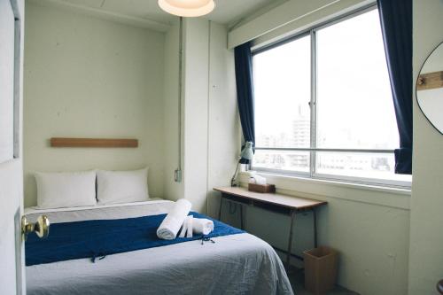 东京努伊酒吧酒廊旅舍的小房间设有床和窗户