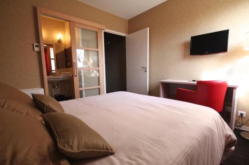 Latresne德桑酒店的卧室配有白色的床和红色椅子