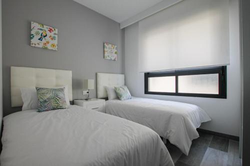 皮拉尔－德拉奥拉达达Higuericas Costa 412 - Rooftop terrace and pool view 300 m from beach的一间卧室设有两张床和窗户。