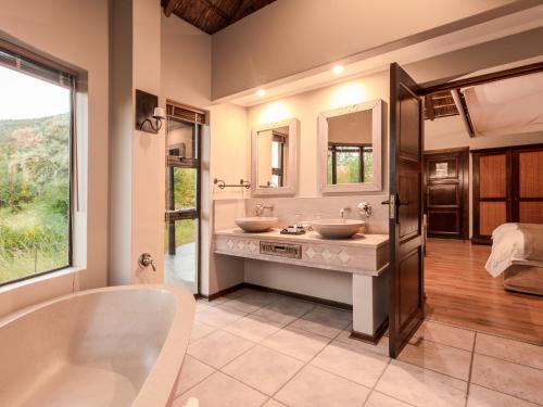 兰斯堡象牙树野游山林小屋的浴室配有两个盥洗盆和浴缸。