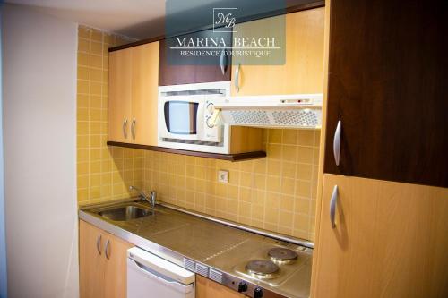 米迪克Marina Beach Appart Hôtel的一间带水槽和微波炉的小厨房