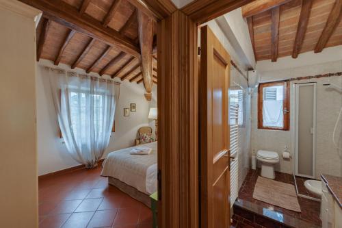 圣吉米纳诺Casa Irene的一间卧室配有一张床,浴室设有卫生间