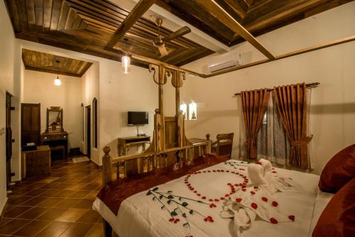 马拉利库兰Flamingo Boutique Hotel & Ayurvedic spa的一间卧室配有一张大床,床上插着花朵