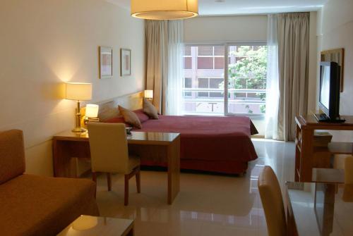布宜诺斯艾利斯巴提蒙公寓的一间卧室配有一张床、一张桌子和一个窗户。