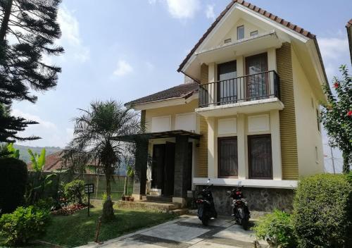 普卡Villa kota bunga N8的停在黄色房子前面的摩托车