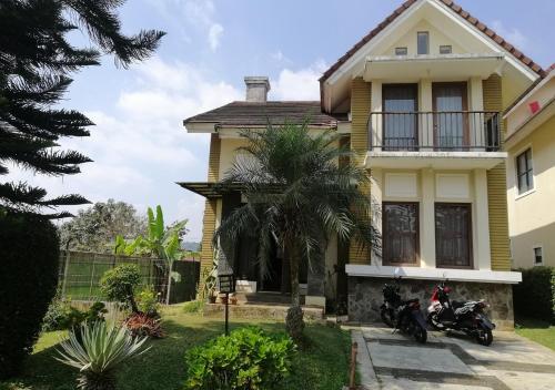 普卡Villa kota bunga N8的两辆摩托车停在前面的黄色房子