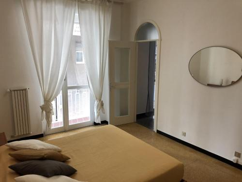 阿尔本加Appartamento Quadrilocale的一间卧室配有一张床、镜子和窗户