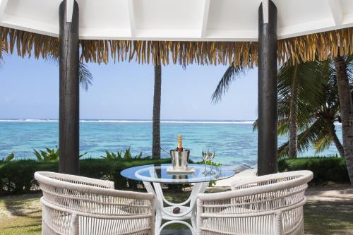 拉罗汤加Motu Beachfront Art Villas的一张桌子和椅子,背景是大海