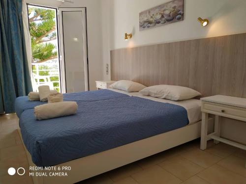 马塔拉玛丽娜酒店的一间卧室设有两张带蓝色床单的床和窗户。