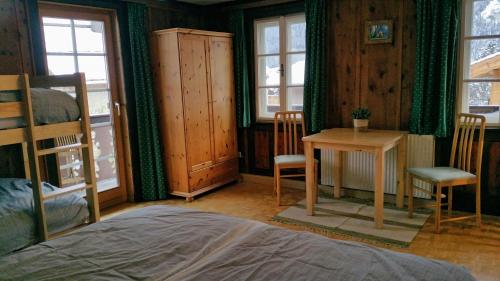 维尔德科格尔山麓布兰贝格Villa Zeppelin - App Smaragd的卧室配有一张床和一张桌子及椅子
