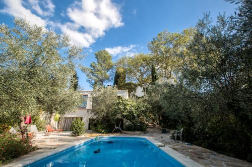 于泽斯Duché d'Uzès Villa Celina Avenue des Cévennes的一座树木繁茂的房屋前的游泳池
