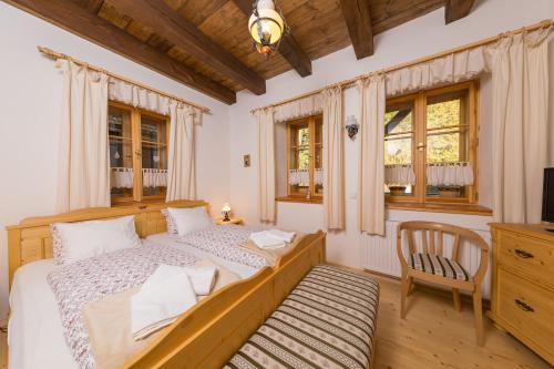大卡尔洛维采Valašské chalupy Resort的一间卧室配有一张床、一把椅子和窗户。
