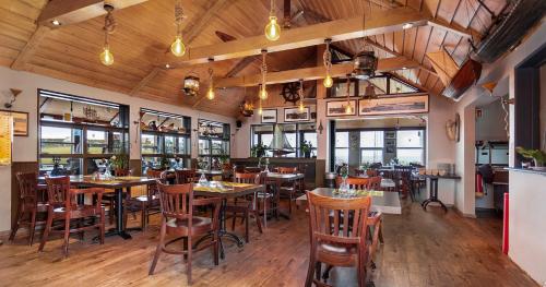 凯夫拉维克Hotel Duus by Keflavik Airport的餐厅设有木桌、椅子和窗户。