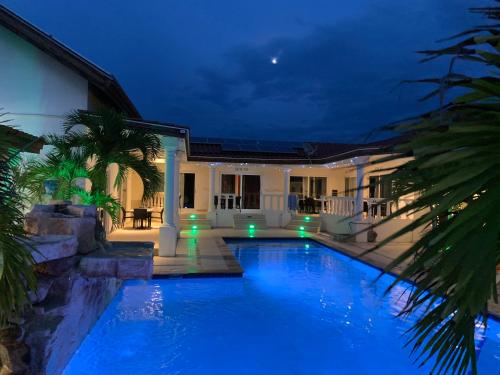 棕榈滩Boutique Hotel Swiss Paradise Aruba Villas and Suites的夜间在房子前面的游泳池