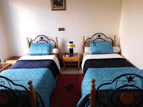 塔鲁丹特提奥特酒店的配有两张蓝色和黑色床单的床铺