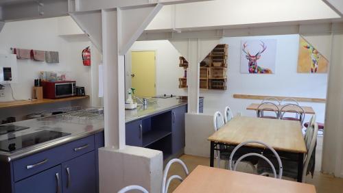 派西亚Centabay Lodge and Backpackers的厨房配有蓝色橱柜和木桌