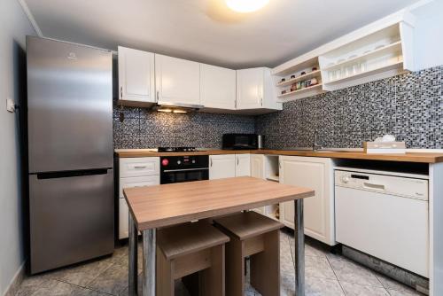 阿拉德Cozy, quiet & family friendly in Arad的厨房配有不锈钢冰箱和木桌