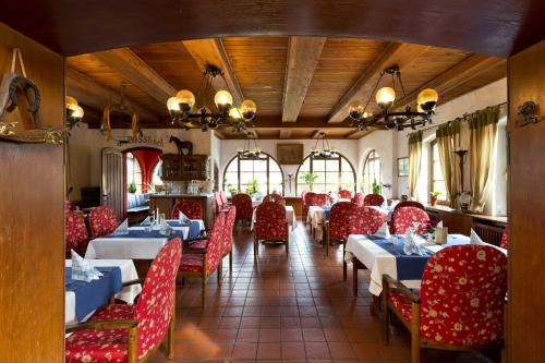 格赫伦-莱宾舒梅德乡村酒店的餐厅内带红色椅子和桌子的用餐室
