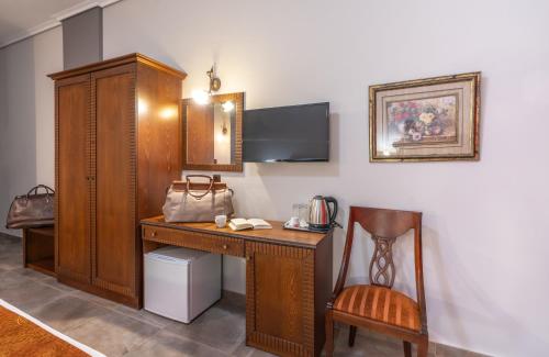 帕拉利亚卡泰里尼斯Paralia Beach Boutique Hotel的客房设有木制书桌和椅子。