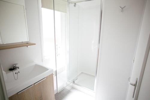 Courtils圣米歇尔露营酒店的白色的浴室设有水槽和淋浴。