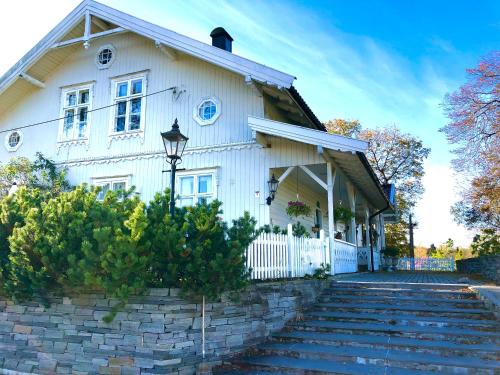 希Gjedsjø Gaard的白色的房子,设有白色的围栏和楼梯