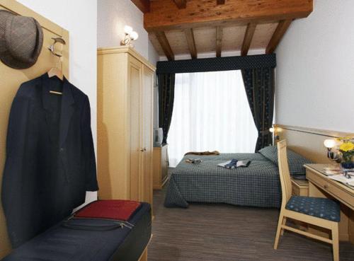 坎帕尔托玛莉酒店的一间卧室设有两张床、一张桌子和一个窗口。