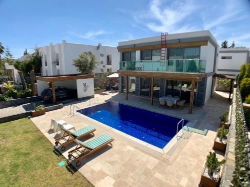 博德鲁姆Ultra Luxury Private Villa with Swimming Pool的房屋前有游泳池的房子