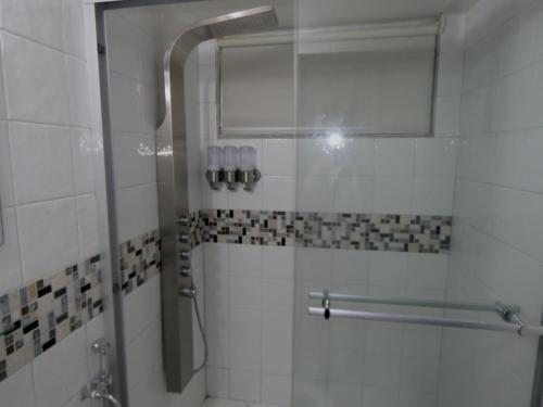 巴拿马城SERENADE Lodging Rooms的浴室里设有玻璃门淋浴