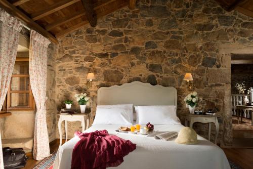 圣地亚哥－德孔波斯特拉托雷布兰卡旅馆的一间卧室配有一张石墙床