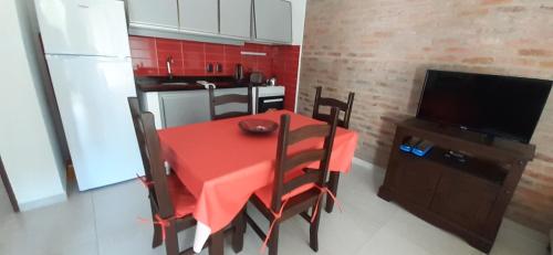 圣安娜Los Cardenales的厨房配有红色的桌椅和电视