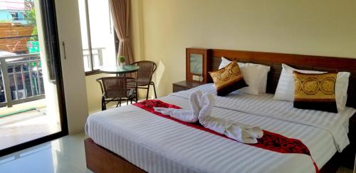 芭东海滩KANPAI HOTEL的一间卧室配有一张带白色床单的大床