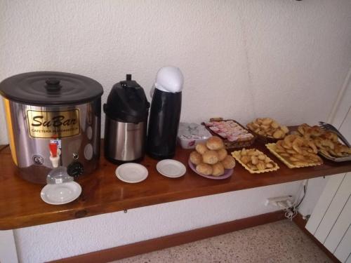 米拉玛Hotel Neptuno的一个带咖啡壶的架子和上面的食物