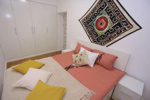 撒马尔罕Newly Renovated Modern 2 Bed Apt Near Gur-e-Amir的一间卧室配有带色彩缤纷枕头的床。