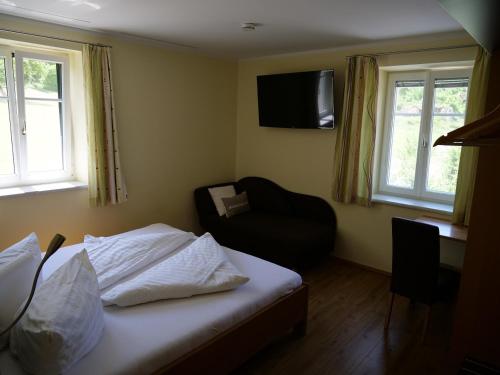 梅尔克鲁格农场酒店的一间卧室配有一张床、一把椅子和电视