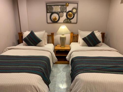 哈林海滩哈林里士满旅馆的客房设有两张床和一张带台灯的桌子。