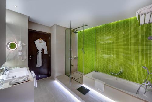 沙迦Hotel 72 Sharjah Waterfront的带浴缸、水槽和淋浴的浴室