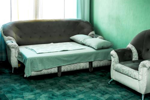 RakitnyyАпартаменты Кирова, 83的房间里的一张沙发和两把椅子