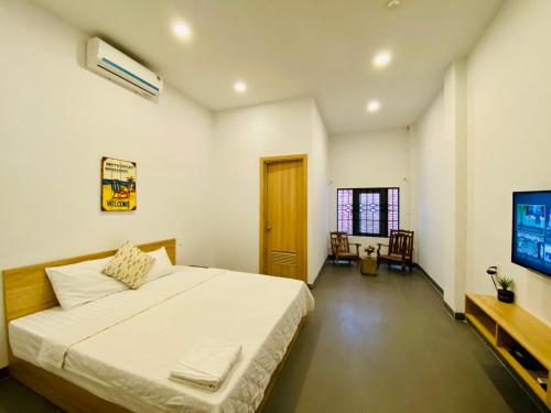 芽庄Vitamin Sea Homestay Nha Trang的一间带大床和电视的卧室