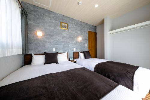 富士河口湖21 ORIYA Mt Fuji -縁ENISHI-的两张睡床彼此相邻,位于一个房间里