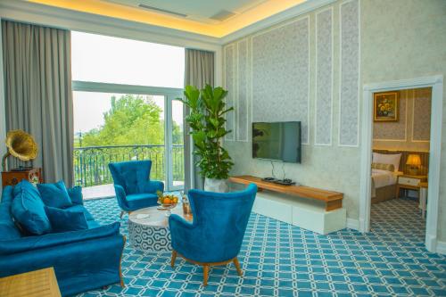 巴库Promenade Hotel Baku的客厅配有蓝色椅子和电视