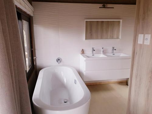 侯斯普瑞特Kingfisher Creek Safari Lodge的浴室配有大型白色浴缸和水槽