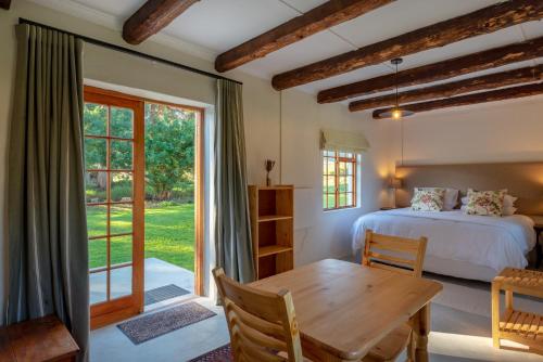 克莱因蒙德Honeyrock Cottages的一间卧室配有一张床、一张桌子和一个窗户。