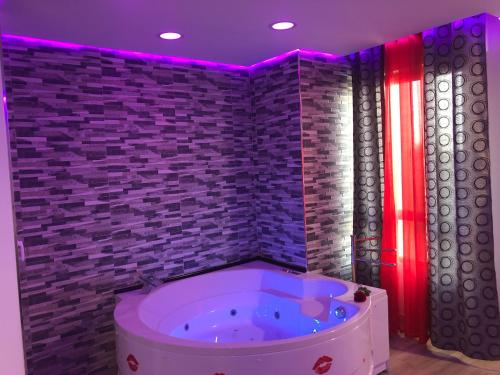 阿尔赫西拉斯Loft romántico的一间带浴缸的浴室,位于一间砖墙客房内