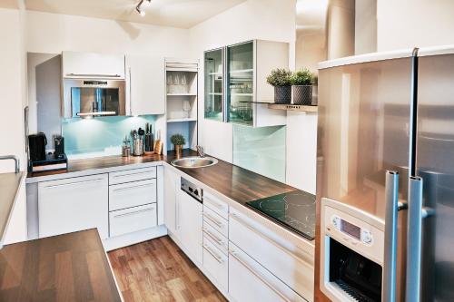 格拉茨Kaiser Apartments - City Centre of Graz的厨房配有白色橱柜和不锈钢用具
