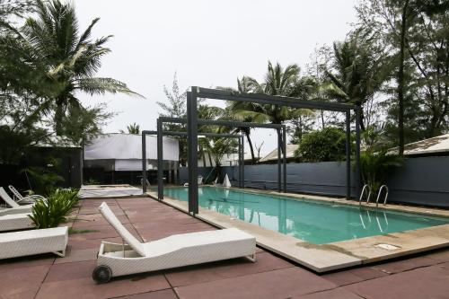 莫尔吉姆Marbela Beach Resort的游泳池旁设有2把白色躺椅