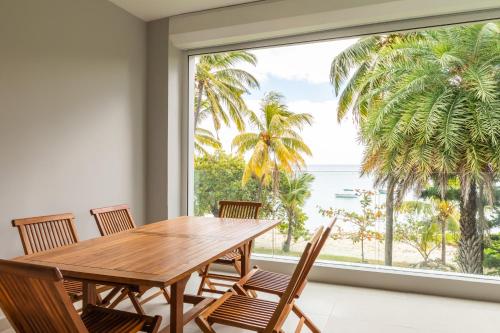 塔马兰CAPLAGE -Beach Front Luxury Apartment at Searock的一间带桌椅和大窗户的用餐室