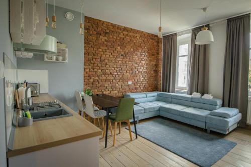 波兹南Apartamenty Vilda的客厅设有蓝色的沙发和砖墙