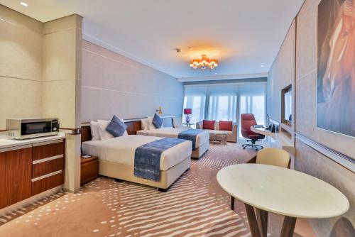 多哈VIP Hotel Doha Qatar的酒店客房设有两张床和电视。